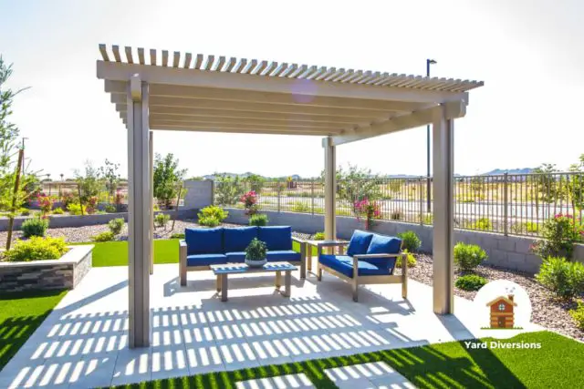 High quality pergola located on a patio on the yard grass with amazing blue patio furniture and shrubbery