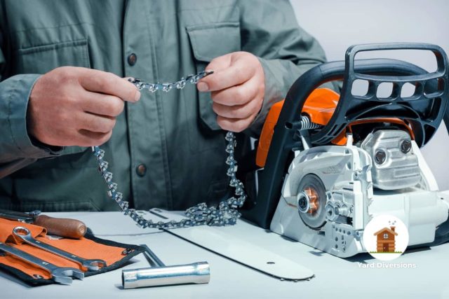 Man assembling a chainsaw and holding the balde up to inspect it for defects