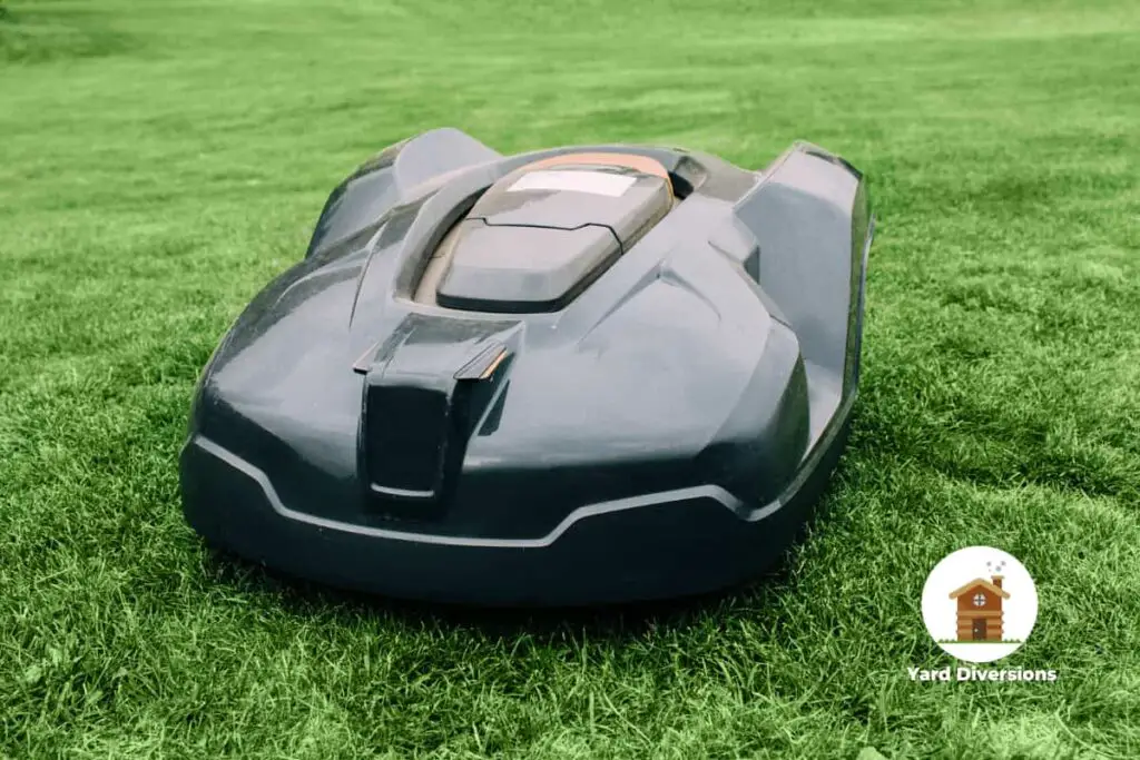 A robotic lawn mower sitting idle on freshly mowed grass