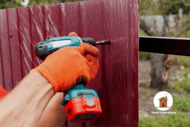 Worker assembling a fence with a Makita drill