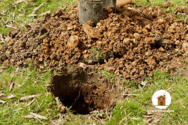 post hole being dug in preparation for concrete and fence post