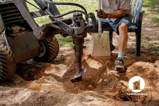 Large digger with a man controlling it digging in dry dirt