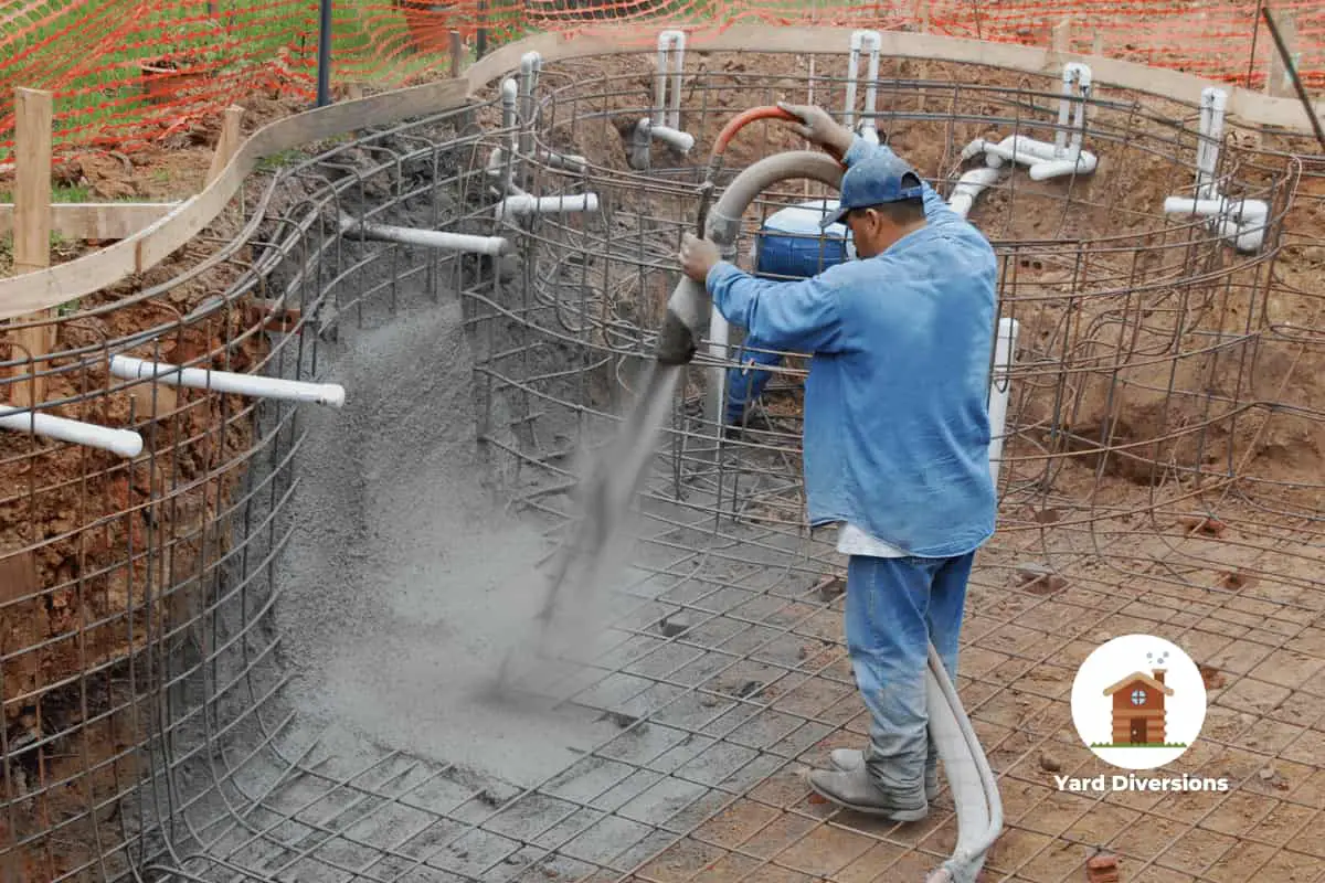 Man spraying concrete into a framed out pool