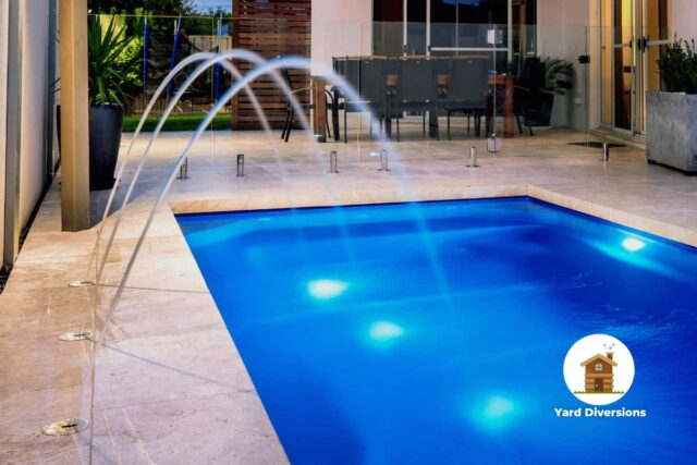 Brilliant blue pool with three pool aerators shooting water through the air back into the pool