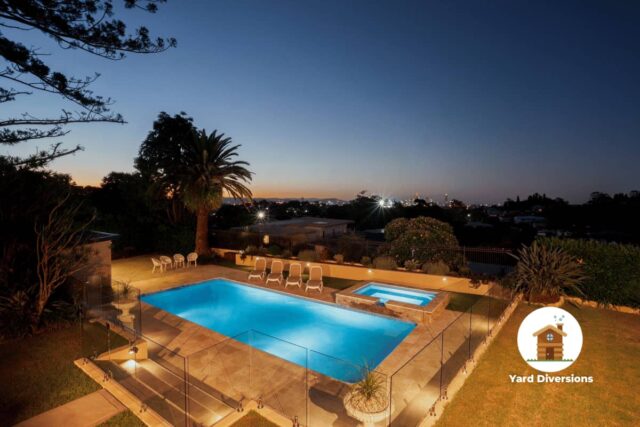 Dusk at a nice pool enclosed in a high-end glass fence