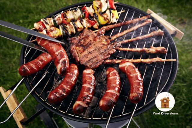 Assorted meats being barbequed on a round grill in the backyard
