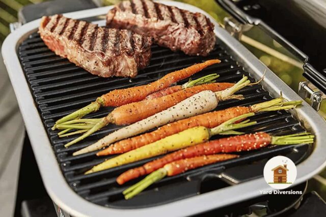 Carrots and steaks cooking on a Weber Lumin electric grill on a backyard deck