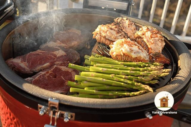 An assortment of meats and veggies being grilled on a Kamado