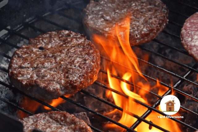 Hamburgers grilling over open flame