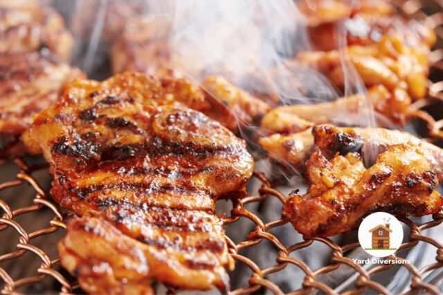 Juicy chicken grilling on a metal grill with smoke rising