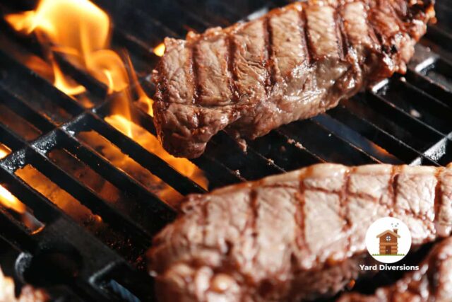 Steak being grilled on a open flame bbq