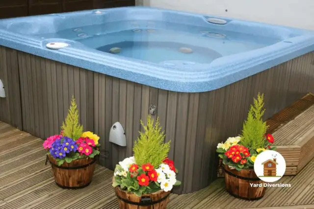 Hot tub on a nice compost looking deck with flower pots for pretty colors
