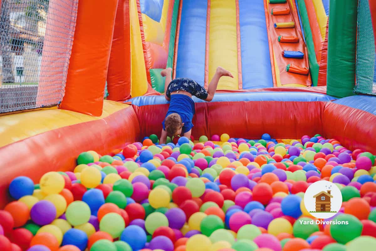 Inflatable bounce house with a slide dropping the rider into a ball pit