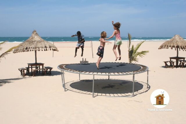 Kids using a trampoline on the beach which was assembled on site