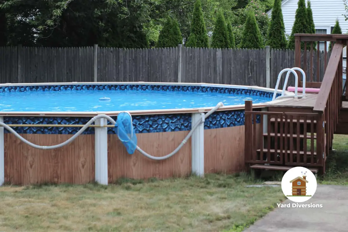 Above ground pool with a nice stairway to a small attached deck to get in and out easy