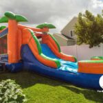 Large bounce house in the backyard with a slide