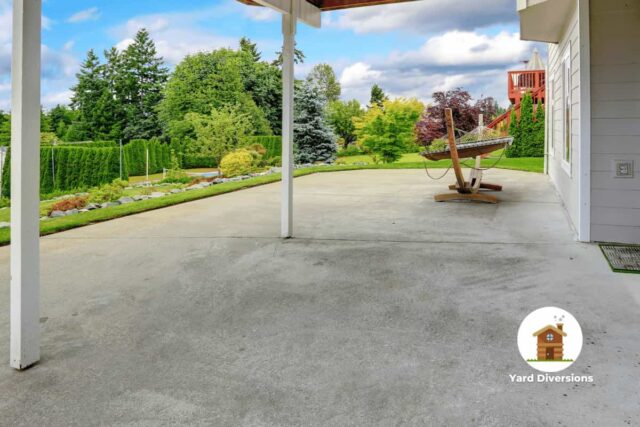 Clean concrete patio in the backyard with a hammock stand and roof for rain protection