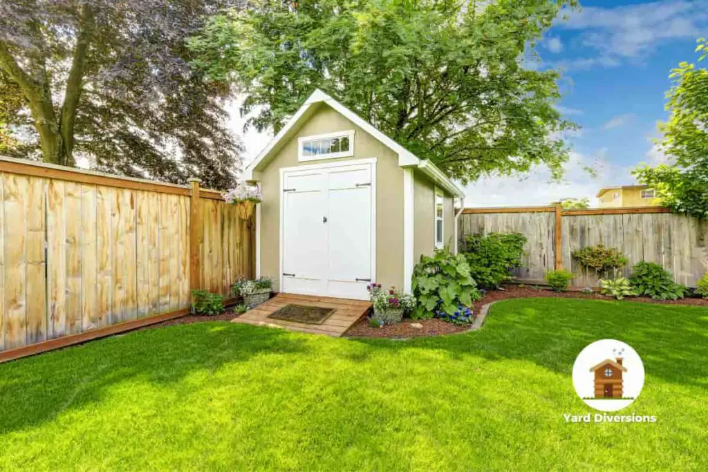 Backyard shed in the corner of the yard with green luscious grass around it