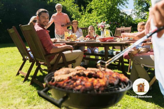 Family gathered in the backyard around the table enjoying a bbq meal