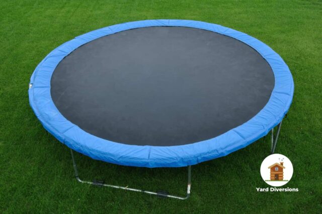 Nice newly assembled trampoline on the grass with sandbags to hold it down