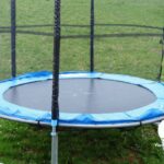 Empty trampoline sitting on the grass in the backyard