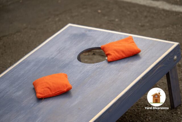 Blue cornhole board with bean bags