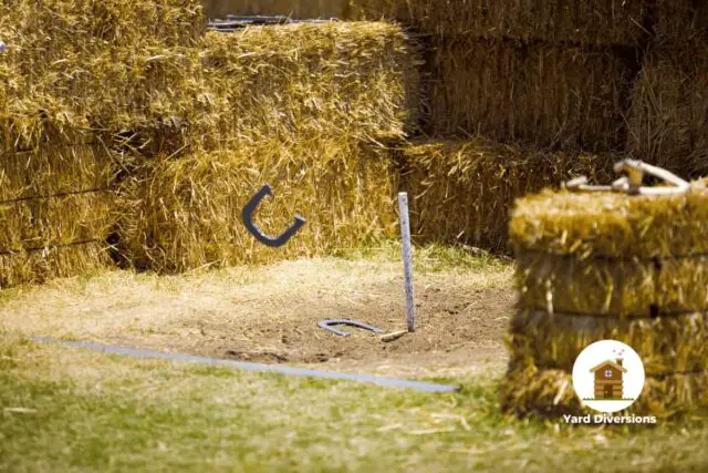 Horseshoe pit surroundded by hay bales